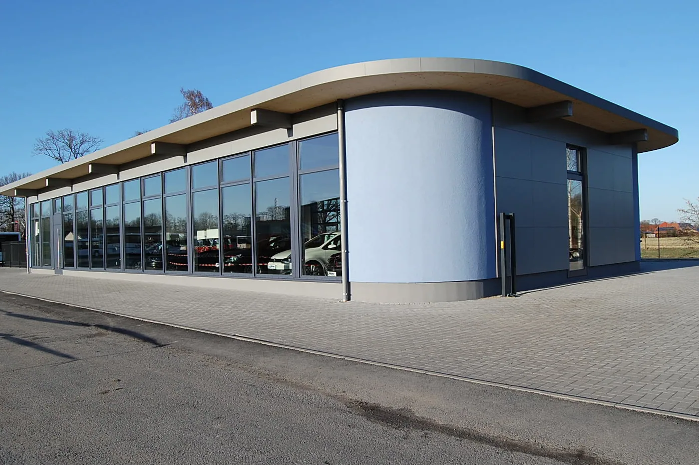 Das Gebäude von Hölscher Automobile in Nordkirchen-Capelle: geschwungenes Dach über der Glasfront der Ausstellungshalle